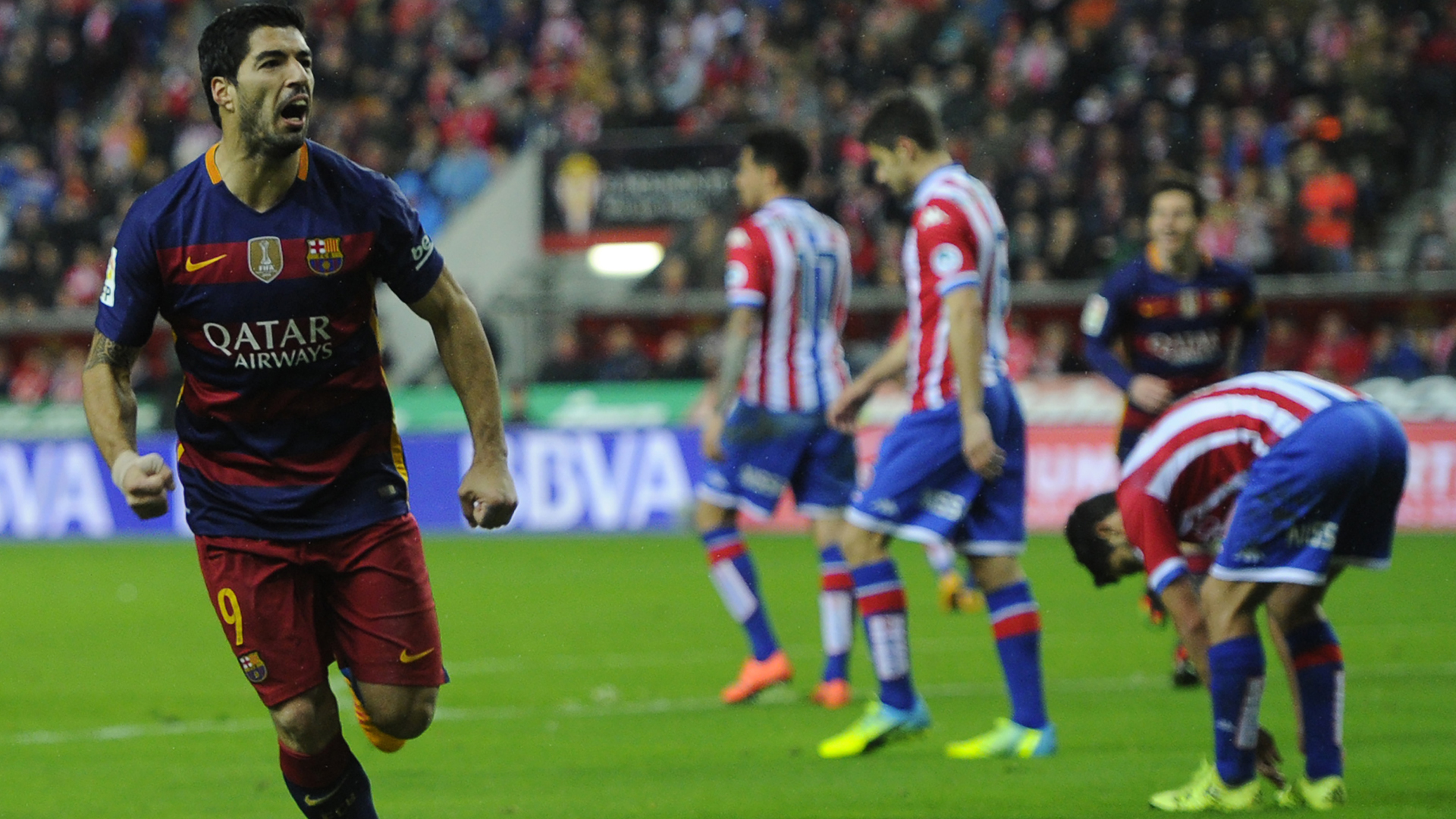 Barcelona's Uruguayan forward Luis Suarez (L) celebrates after scoring a goal during the Spanish league football match Real Sporting de Gijon vs FC Barcelona at El Molinon stadium in Gijon on February 17, 2016.  AFP PHOTO / MIGUEL RIOPA / AFP / MIGUEL RIOPA        (Photo credit should read MIGUEL RIOPA/AFP/Getty Images)