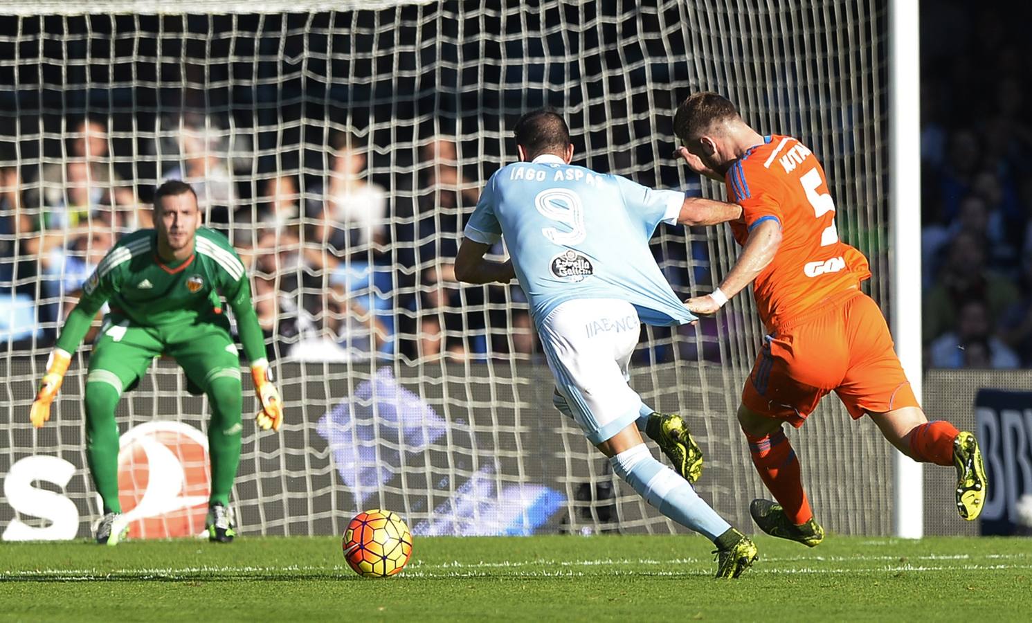Celta Vigo's forward Iago Aspas (C) runs for the ball with Valencia's German defender Shkodran Mustafi during the Spanish league football match RC Celta de Vigo vs Valencia CF at the Balaidos stadium in Vigo on November 7, 2015.   AFP PHOTO/ MIGUEL RIOPA