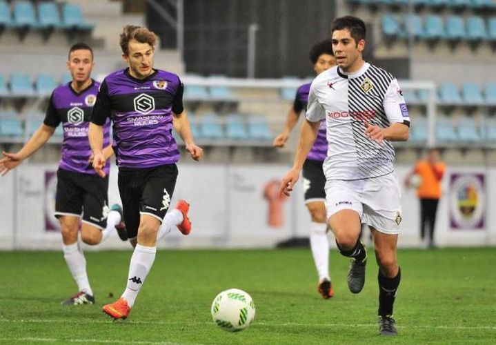 Roni conduce el balón en el encuentro entre CD Palencia y Caudal Deportivo