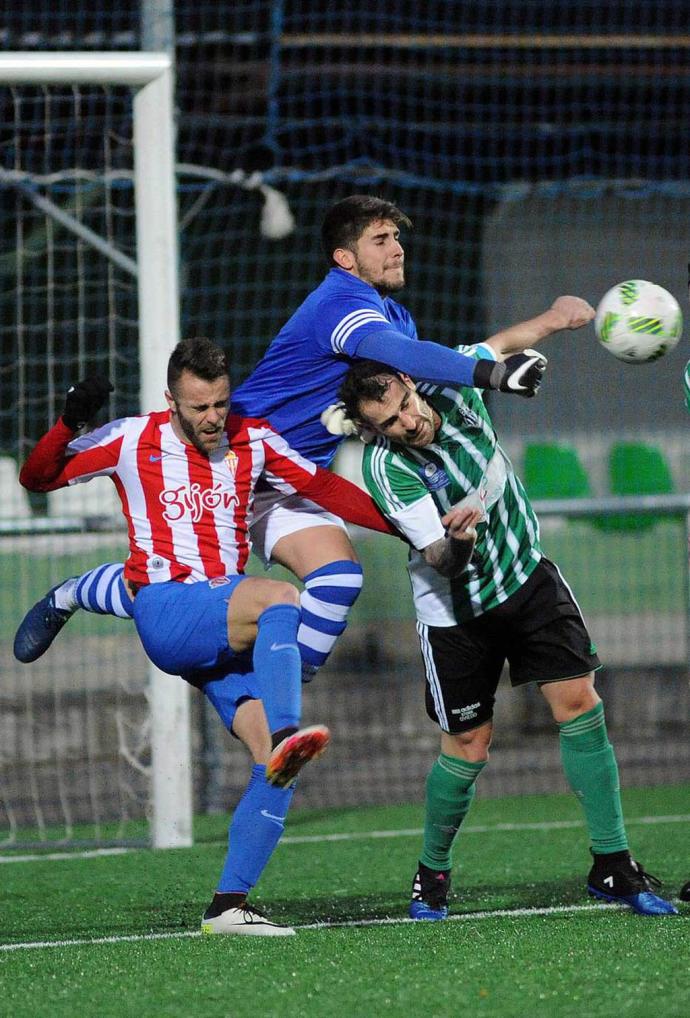 Adán (Lenense) despeja de puños ante la oposición de Álvaro (Sporting 'B') - Foto: La Nueva España