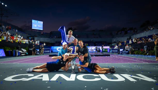 Swiatek con su equipo posando con el trofeo de las WTA Finals y con una tarta y un globo, ambos con forma de 1 simbolizando su vuelta a la cima del tenis mundial.